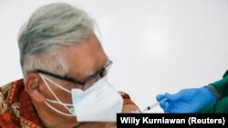 S. Parlindungan Gultom, seorang dokter berusia 76 tahun, menerima suntikan dosis pertama vaksin COVID-19 buatan Sinovac Biotech, setelah BPOM menyetujui penggunaan vaksin Sinovac untuk lansia, di Jakarta, 8 Februari 2021. (Foto: Willy Kurniawan/Reuters)