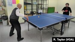 Retired couple Ru-Liang Zhang, left, and Xan-Xia Hong play a game of ping pong at the New York Chinese Community Center, where they spend their weekday afternoons.