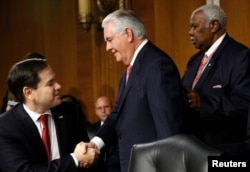 FILE - Rex Tillerson, center, the former chairman and chief executive officer of ExxonMobil, shakes hands with U.S. Senator Marco Rubio (R-FL) as he arrives for a Senate Foreign Relations Committee confirmation hearing to become U.S. Secretary of State.