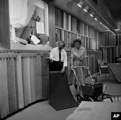 A customer examines carpet samples at Sears Roebuck department store in Niles, Illinois, Aug. 23, 1961.