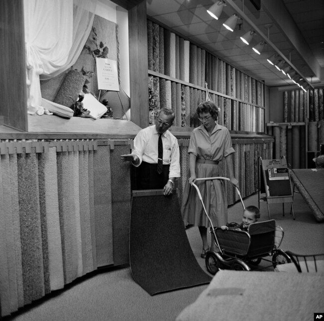 A customer examines carpet samples at Sears Roebuck department store in Niles, Illinois, Aug. 23, 1961.