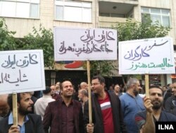 Supporters of Iran's national trade union hold banners saying, "Workers have empty tables," right, and "Laborers in western Tehran have no place to gather," center, at a May Day rally at Tehran's Workers' House, May 1, 2018.