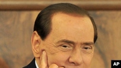 Italian Prime Minister Silvio Berlusconi looks on as he attend a meeting with Confcommercio in Milan, February 28, 2011