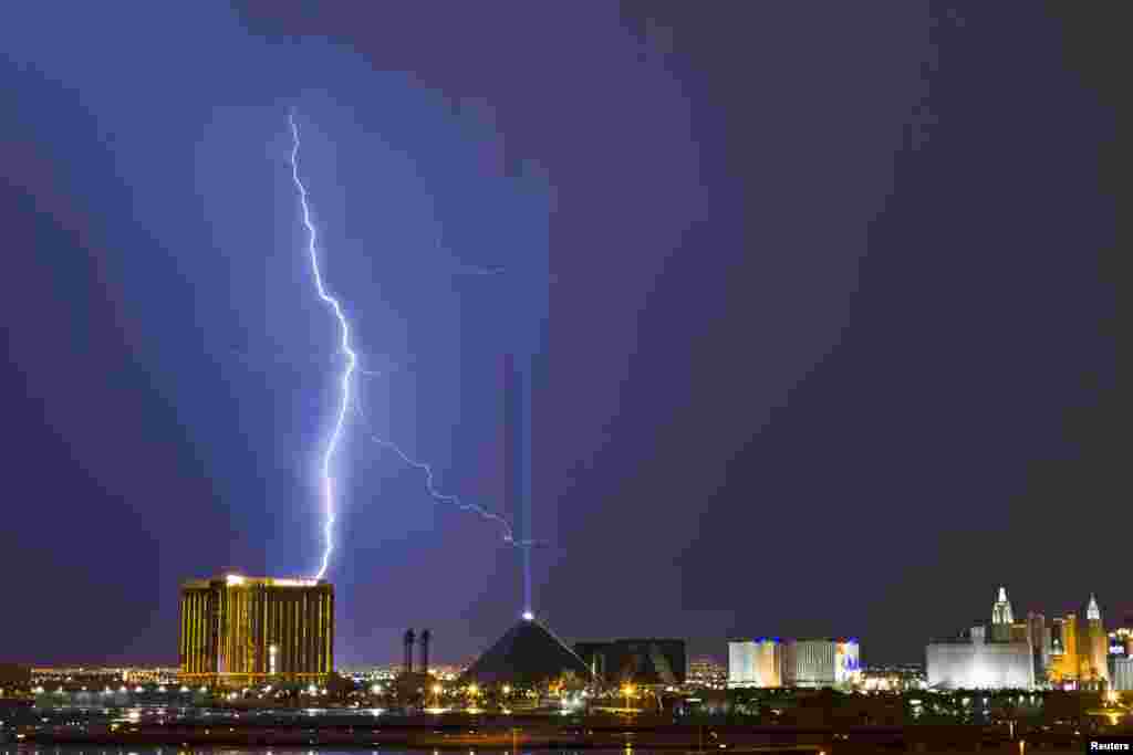Các tia sét phía trên khách sạn Mandalay Bay (trái) và sòng bạc Luxor (giữa) ở Dải Las Vegas trong khi một trận bão thổi qua thành phố Las Vegas, tiểu bang Nevada, Hoa Kỳ, 20/7/13