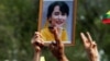 ထိုင်းနိုင်ငံ ဘန်ကောက်မြို့ရှိ ထိုင်းရောက် မြန်မာနိုင်ငံသားတွေ စစ်အာဏာရှင် ဆန္ဒပြပွဲအတွင်း ကိုင်ဆောင်ထားတဲ့ ဒေါ်အောင်ဆန်းစုကြည်ရဲ့ ဓာတ်ပုံ။ (ဖေဖော်ဝါရီ ၂၂၊ ၂၀၂၁)