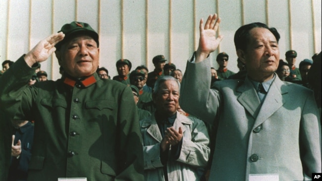 资料照片: 1981年9月，时任中国军委主席邓小平身穿军装和时任中共总书记胡耀邦一起检阅部队。