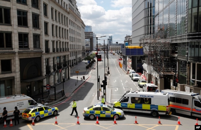 Camionetas y autos de la policía bloquean el acceso a una avenida luego del ataque en el Puente de Londres.