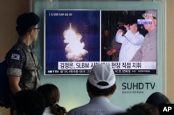 Người lính quân đội Hàn Quốc theo dõi một chương trình tin tức chiếu hình ảnh được báo Rodong Simun của Triều Tiên công bố về việc Bắc Triều Tiên phóng tên lửa đạn đạo dưới sự giám sát của lãnh đạo Triều Tiên Kim Jong - un, tại ga Seoul, Hàn Quốc.