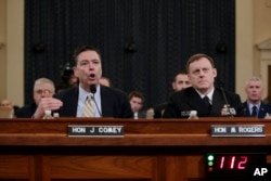 FILE - FBI Director James Comey, left, joined by National Security Agency Director Mike Rogers, testifies on Capitol Hill in Washington before the House Intelligence Committee on allegations of Russian interference in the 2016 U.S. presidential election campaign, March 20, 2017.