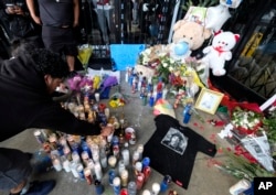 Fans of rapper Nipsey Hussle are seen gathered at a makeshift memorial in the parking lot of Hussle's Marathon Clothing store in Los Angeles, April 1, 2019.