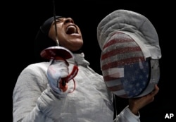 American Ibtihaj Muhammad celebrates after winning a point to Russia in a women's team sabre fencing semifinal at the 2016 Summer Olympics in Rio de Janeiro, Brazil, Aug. 13, 2016.