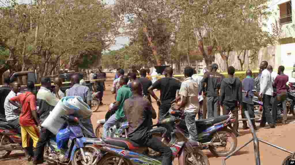 Des badauds se rassemblent dans la rue qui mène à la boîte de nuit qui a été attaquée par des hommes armés à Bamako, au Mali, samedi 7 Mars 2015.