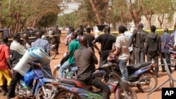 Des conducteurs des motos contemplent le lieu d'un attaque à l'explosif au Mali, le 7 mars 2015.