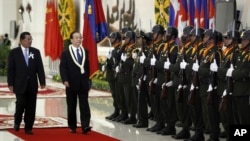 China's Premier Wen Jiabao, second form left, inspects honor guards with Cambodia's Prime Minister Hun Sen, left, during an official welcoming ceremony in Phnom Penh, file photo. 