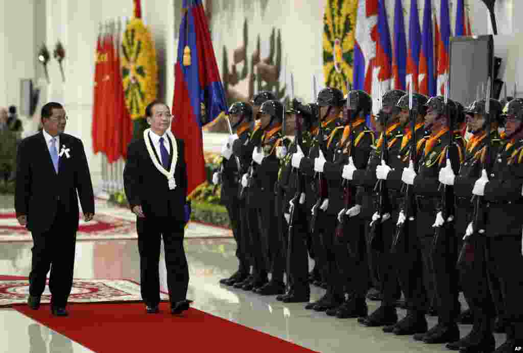 China&#39;s Premier Wen Jiabao, second form left, inspects honor guards with Cambodia&#39;s Prime Minister Hun Sen, left, during an official welcoming ceremony in Phnom Penh, Cambodia, Sunday, Nov. 18, 2012. (AP Photo/Vincent Thian)