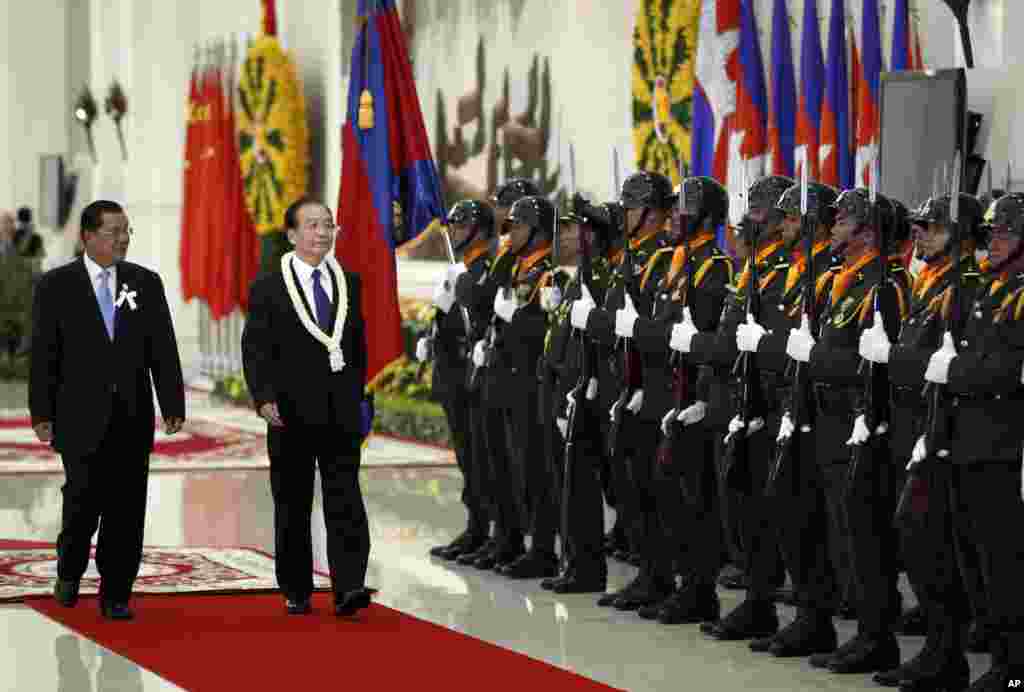 China's Premier Wen Jiabao, second form left, inspects honor guards with Cambodia's Prime Minister Hun Sen, left, during an official welcoming ceremony in Phnom Penh, Cambodia, Sunday, Nov. 18, 2012. (AP Photo/Vincent Thian)