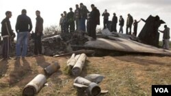 Residentes libios se reúnen en torno a los restos del avión de combate estaodunidense F15 que se estrelló cerca de Bu Mariem, al este de Bengasi.