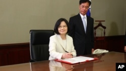 Taiwan's President Tsai Ing-wen signs her first document at her new desk following the inauguration ceremony at the Presidential Office in Taipei, Taiwan May 20, 2016. 
