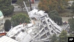 Rescue workers look for victims on the collapsed Pyne Gould Guinness building where people remain trapped after a 6.3 earthquake hit the city of Christchurch, New Zealand, February 22, 2011