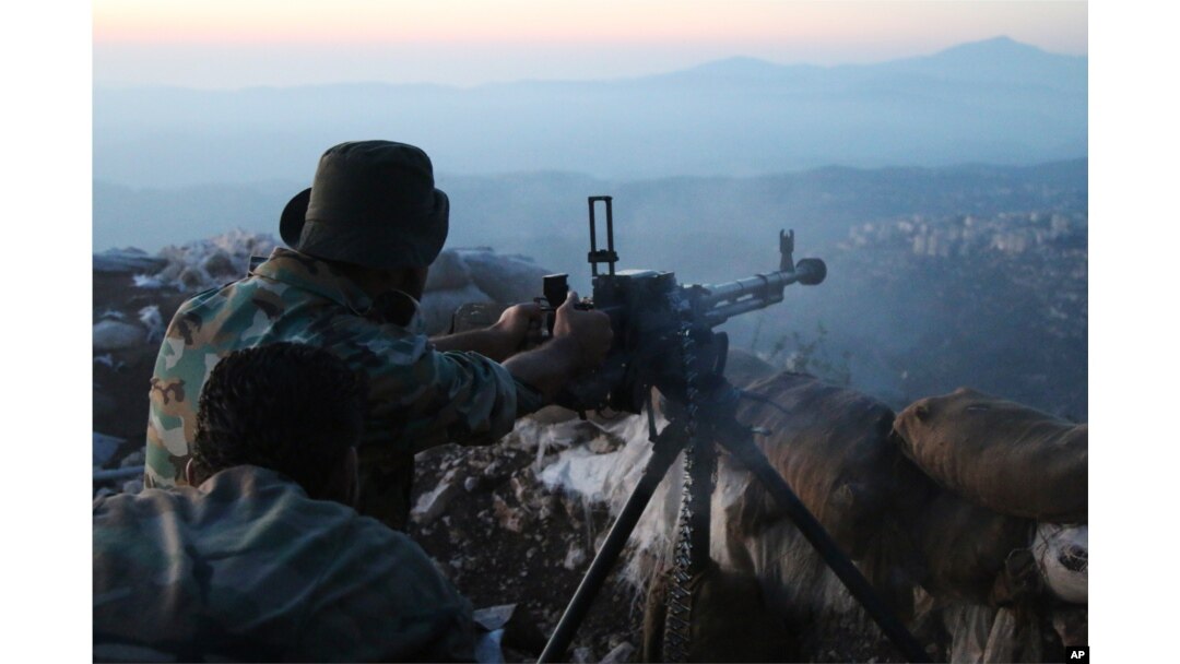 Syrian army personnel, backed by Russian airstrikes, fires machine gun in Latakia province, near border with Turkey, Oct. 10, 2015.