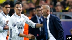 Cristiano Ronaldo de Real Madrid salue l'entraîneur de son équipe, Zinedine Zidane, après avoir ouvert le score lors d’un match de football de la Ligue des champions entre le Borussia Dortmund et le Real Madrid à Dortmund, Allemagne, 27 septembre 2016. 