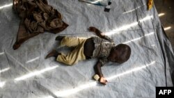 Newly arrived refugee boy from the Democratic Republic of Congo (DRC) sleeps in a makeshift shelter before their registration at Kyangwali Refugee Settlement in Kyangwali, western Uganda, Dec. 10, 2018.