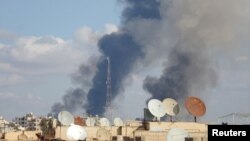 Khói bốc lên từ địa điểm mà các nhà hoạt động nói bị lực lượng trung thành với Tổng thống Syria al-Assad oanh kích, 25/11/14