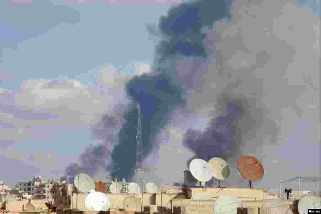 Smoke rises after what activists said were airstrikes by forces loyal to Syria's President Bashar al-Assad in Raqqa, Nov. 25, 2014.