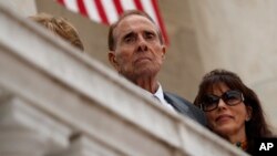 FILE - Former Sen. Bob Dole watches as President Donald Trump speaks during a Memorial Day ceremony at Arlington National Cemetery, May 29, 2017, in Arlington, Virginia.