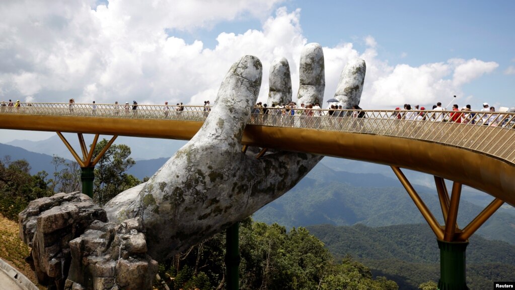 Tourists walk past giant hand structure on the Gold Bridge on Ba Na hill near Danang City, Vietnam August 1, 2018. (REUTERS/Kham)