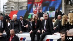 Tomisalv Nikolic, zajedno sa suprugom Danicom, partijskim rukovodstvom i koalicionim partnerima i brojnim simpatizerima sedi na stiroporu ispred Doma narodne skupštine u Beogradu.