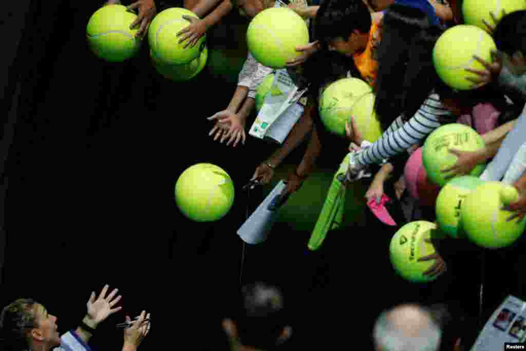 កីឡាការនី Simona Halep មកពីរូម៉ានីចុះហត្ថលេខាដល់អ្នកមើល បន្ទាប់ពីឈ្នះការប្រកួតជាក្រុមរបស់នាងជាមួយនឹងកីឡាការនី Caroline Garcia មកពីបារាំង ក្នុងពេលប្រកួត WTA Finals Tennis នៅស្តាត Singapore Indoor Stadium។
