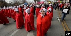 Members of the "Texas Handmaids" lead a women's march to the Texas State Capitol on the one-year anniversary of President Donald Trump's inauguration, Jan. 20, 2018, in Austin, Texas. The costumes are a nod to "The Handmaid's Tale," a novel and television series that tell the story of a dystopian future in which women's rights are suppressed and a class of women are used solely for reproductive purposes.