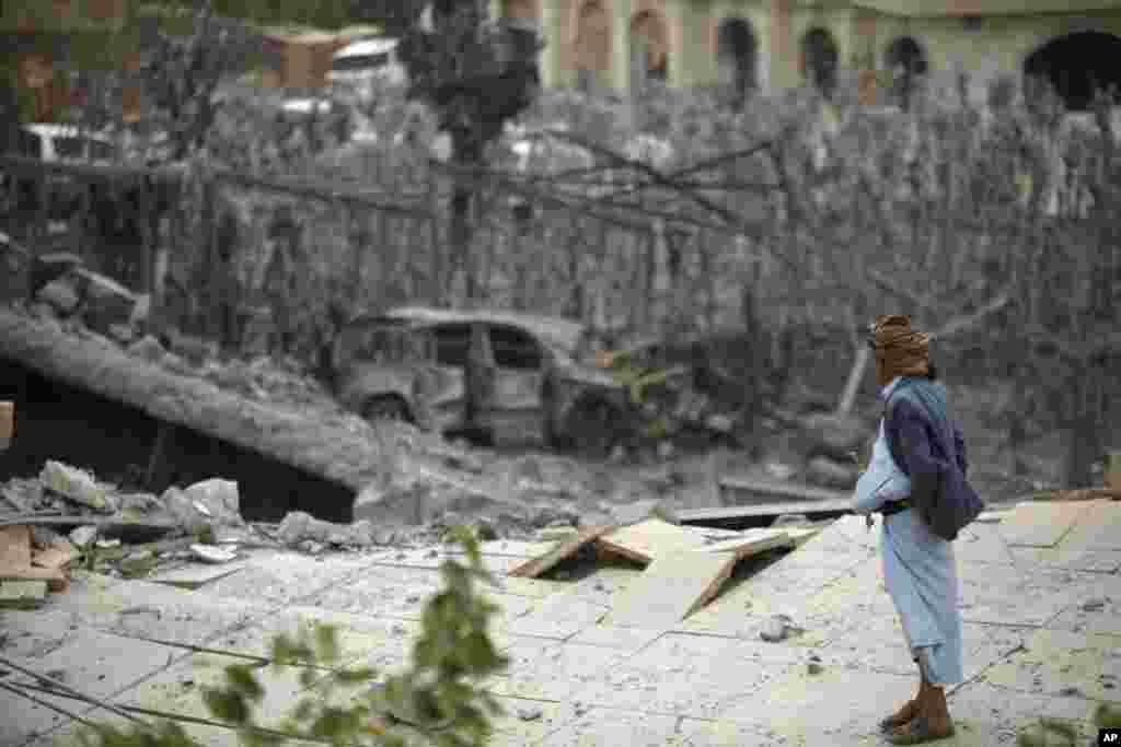 Seorang pria berdiri di atas puing-puing rumah yang rusak akibat serangan udara yang dipimpin oleh Arab Saudi di pinggiran kota Sana&#39;a, Yaman.