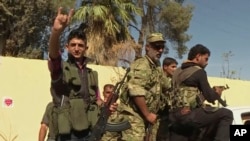 In this image made from video posted online by Qasioun News Agency, members of a Turkish-backed Syrian opposition force patrol in Dabiq, Syria, Oct. 16, 2016. 