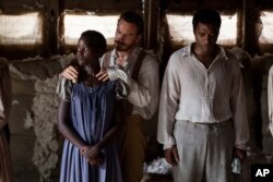 This image released by Fox Searchlight shows Lupita Nyong’o, from left, Michael Fassbender and Chiwetel Ejiofor in a scene from "12 Years A Slave."