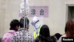 2020年1月22日，武漢一家醫院的醫療人員身穿防護服工作。 （路透社）