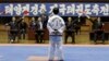 FILE - A North Korean participant in a national Taekwondo festival is judged in front of a sign in Korean that reads “National Taekwondo Festival for Celebrating Day of the Sun” at the Taekwondo Hall in Pyongyang, North Korea, April 7, 2012.