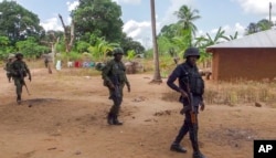 FILE - Rwandan soldiers patrol in the village of Mute, in Cabo Delgado province, Mozambique, Aug. 9, 2021, in this image made from video.