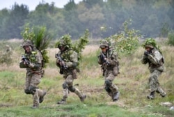 FILE - Soldiers take part in exercises at the Yavoriv military training ground, near Lviv, western Ukraine, Sept 24, 2021, as part of joint drills between the U.S., other NATO countries and Ukraine.