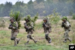 FILE - Soldiers take part in exercises at the Yavoriv military training ground, near Lviv, western Ukraine, Sept 24, 2021, as part of joint drills between the U.S., other NATO countries and Ukraine.