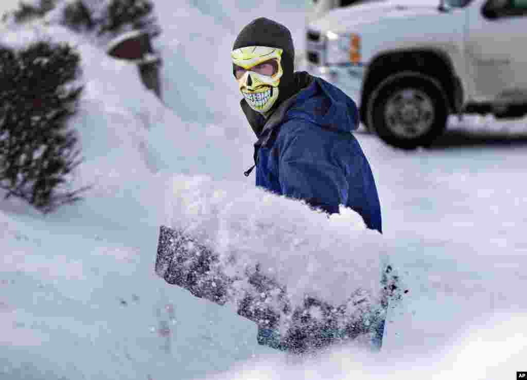 With the temperature a frightful 3 degrees Fahrenheit, Drue Ford shovels snow wearing a face mask to guard against frostbite, Jan. 3, 2014, in Brunswick, Maine.