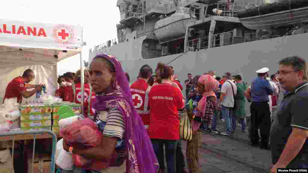 La Croix Rouge italienen distribue un peu de nourriture aux migrants dans le port de Catane, Sicile, 6 octobre 2015 (Nicolas Pinault/VOA).