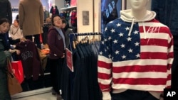 A woman tries out a sweater at a U.S. retailer Gap's flagship store in Beijing, Jan. 10, 2019. Uncertainty over the outcome of China-U.S. trade talks is casting a pall over Asian markets.