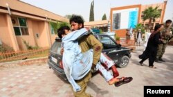 An injured man is carried to a hospital after a car bomb in Jalalabad city, Afghanistan June 17, 2018.