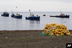 FILE - Fishing boats are seen near the village of Rybaki on Iturup Island, in the Russian Far East, Aug. 20, 2011.