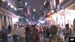 Tourists and locals walk down Bourbon Street in New Orleans