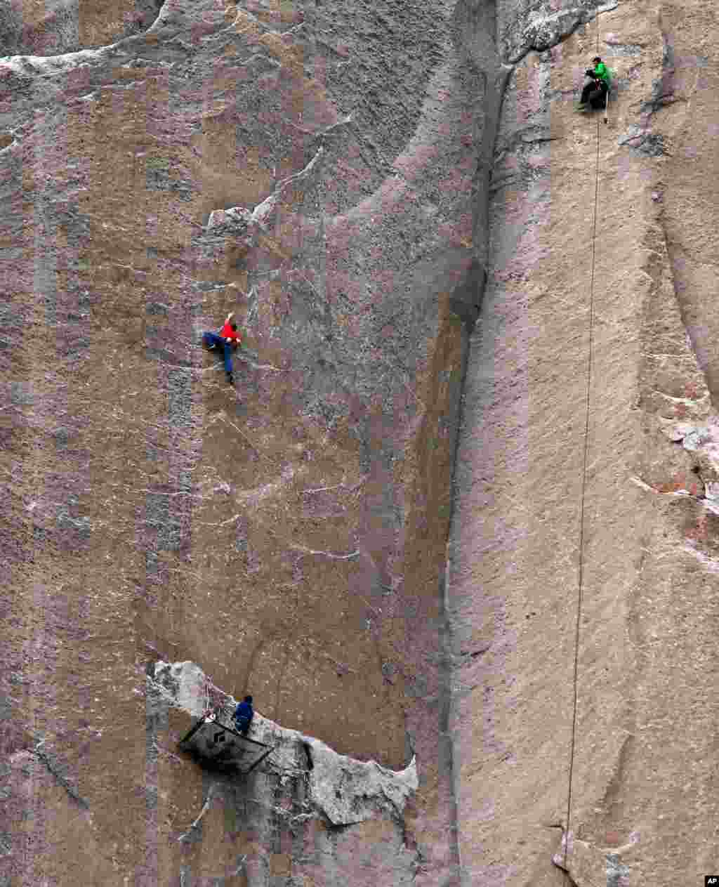 In this Jan. 8, 2015 photo provided by Tom Evans, Tommy Caldwell (in red) climbs Pitch 19 as Kevin Jorgeson secures rope on a rest day, Yosemite National Park, California.