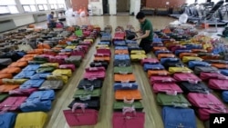 A police official checks some 400 counterfeit bags at the Jungbu police station in Seoul, South Korea, June 1, 2016. 
