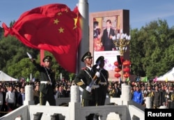 中国武警士兵在拉萨举行的西藏自治区成立50周年庆祝活动升旗仪式期间展开中国国旗。（2015年9月8日）